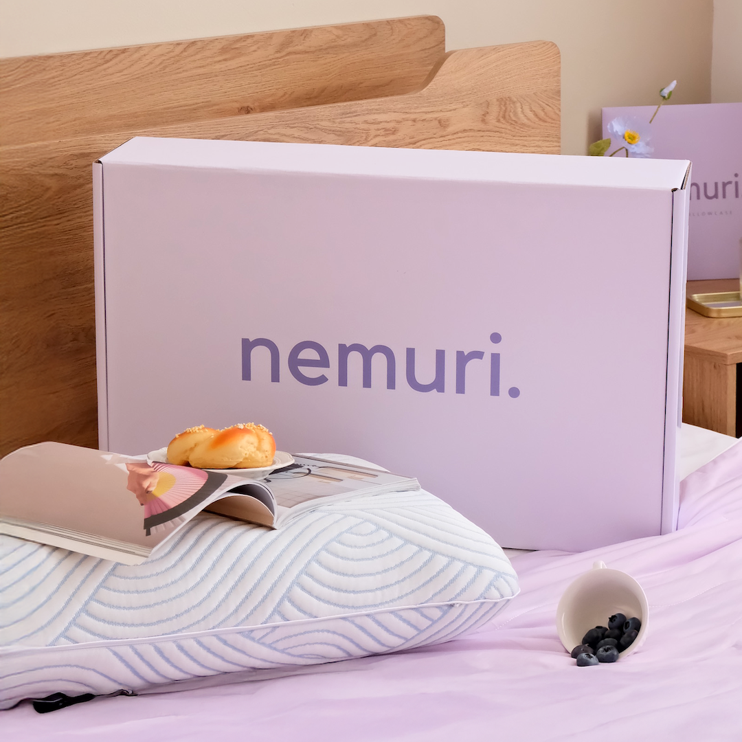 Nemuri product packaging on a bed with a pillow and magazine.