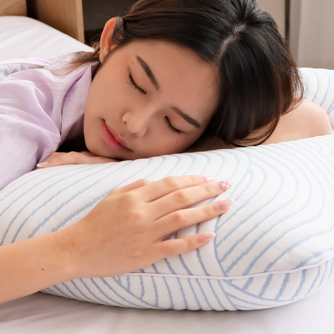 Woman sleeping peacefully on a striped nemuri pillow.